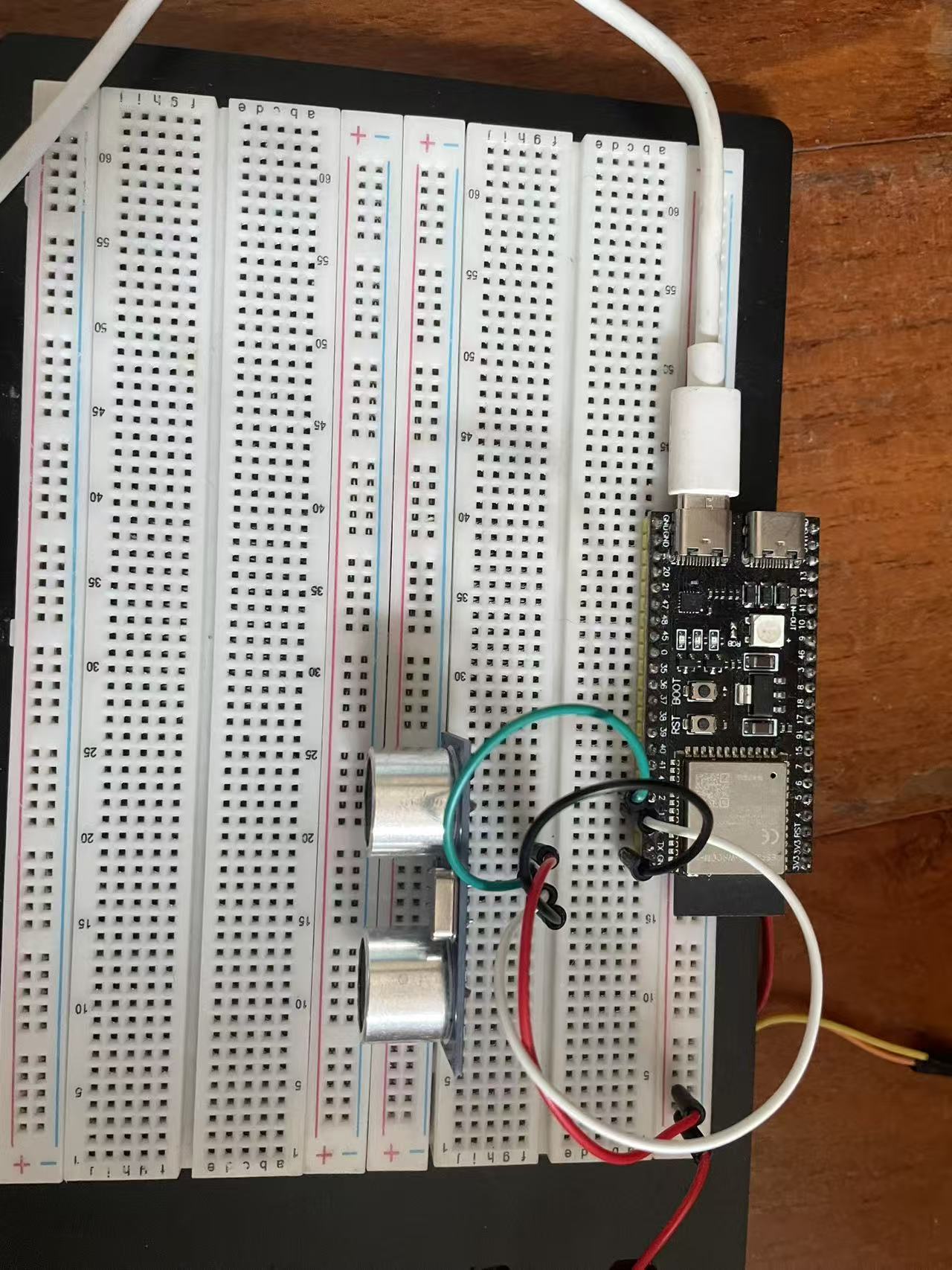 面包板上 HC-SR04 通过四根杜邦线接到 ESP32-S3-DevKitC-1